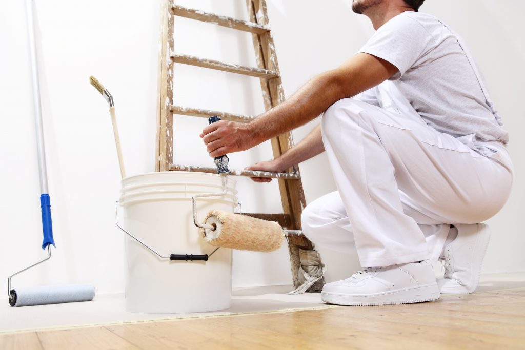 painter man at work with a roller, bucket and scale, bottom view